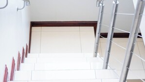Una escalera con barandillas de metal y peldaños blancos.