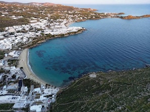 An aerial view of a coastal town with white buildings, a beach, and clear blue waters. - Mykonos Psarou Place, Seaview with Private Jacuzzi (Psarou)