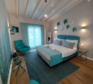 Ein modernes Schlafzimmer mit einem Bett, einem Sessel, einem Spiegel und Wandkunst.