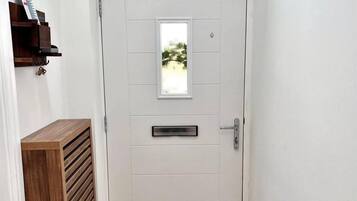 A white door with a small window, a metal handle, and a keyhole.