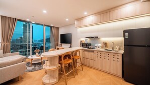 Una cucina moderna con zona pranzo, un frigorifero nero e vista sulla città.