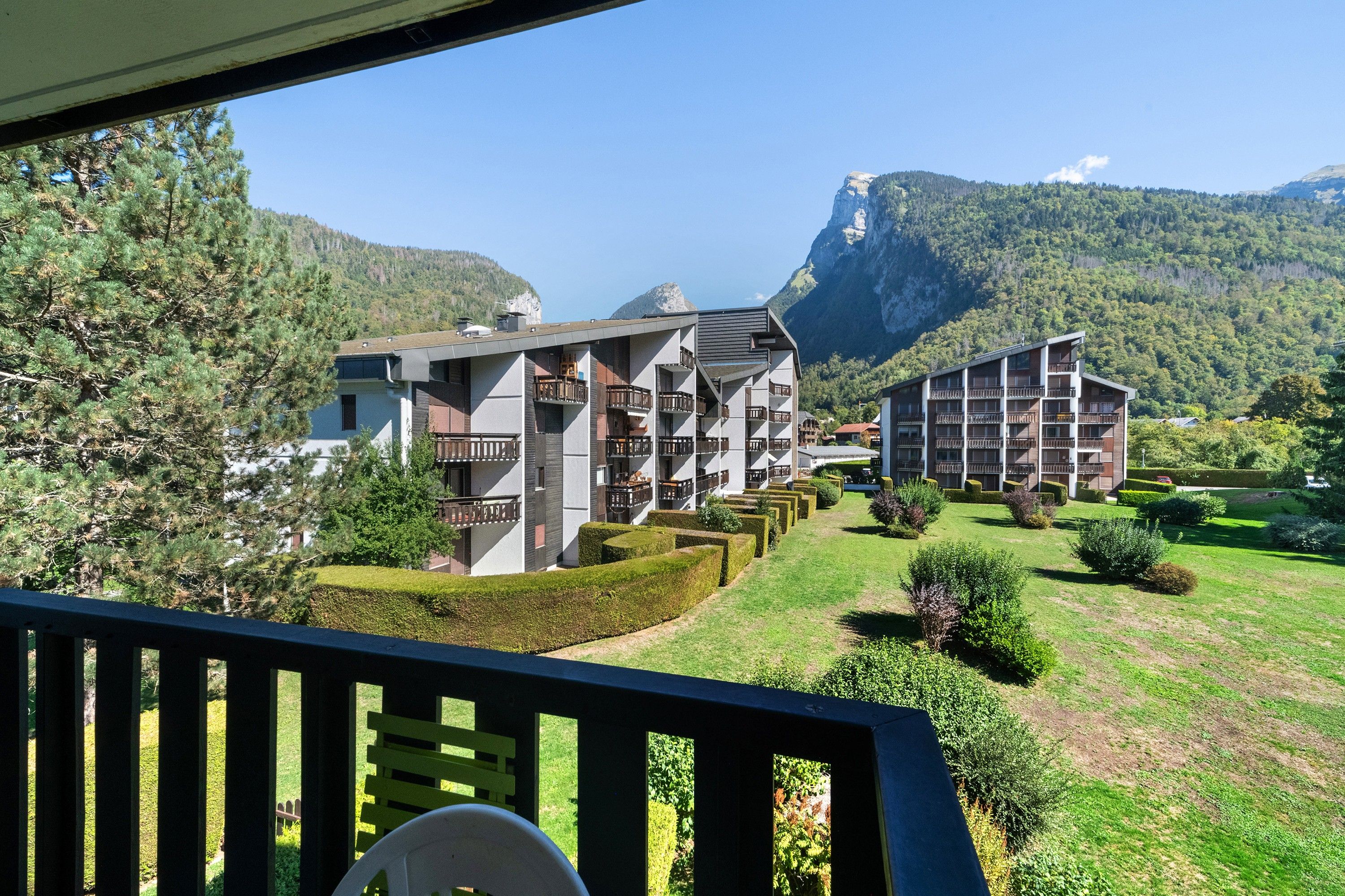 Ein Hotel mit mehreren Etagen, Balkonen und einer Bergkulisse.
