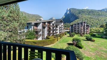 Ein Hotel mit mehreren Etagen, Balkonen und einer Bergkulisse.