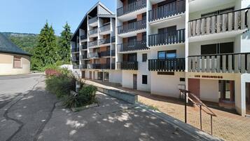 Ein mehrstöckiges Hotel mit Balkonen, einem Parkplatz und einem Schild mit der Aufschrift 'LES EDELWEISS'.