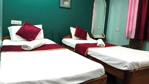 Een hotelkamer met twee bedden, een spiegel, een luchtverkoeler aan de muur en een stopcontact.