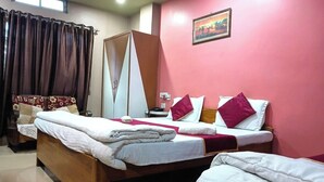 Een hotelkamer met twee bedden, een houten hoofdeinde, een rode wand en een schilderij.