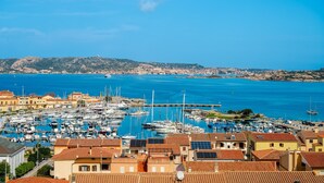 A coastal town with a marina, terracotta-roofed buildings, and a clear blue sky. - Holiday Home 'Mariella' with Sea View and Private Terrace (Palau)
