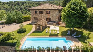 A stone villa with a swimming pool, outdoor seating, and a view of the surrounding landscape. - Villa Raggio di Luce Stigliano (Sovicille)