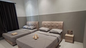 A hotel room with two beds, a ceiling fan, a nightstand, and a small table with a decorative item. - Kuantan putra home (Kuala Lipis)