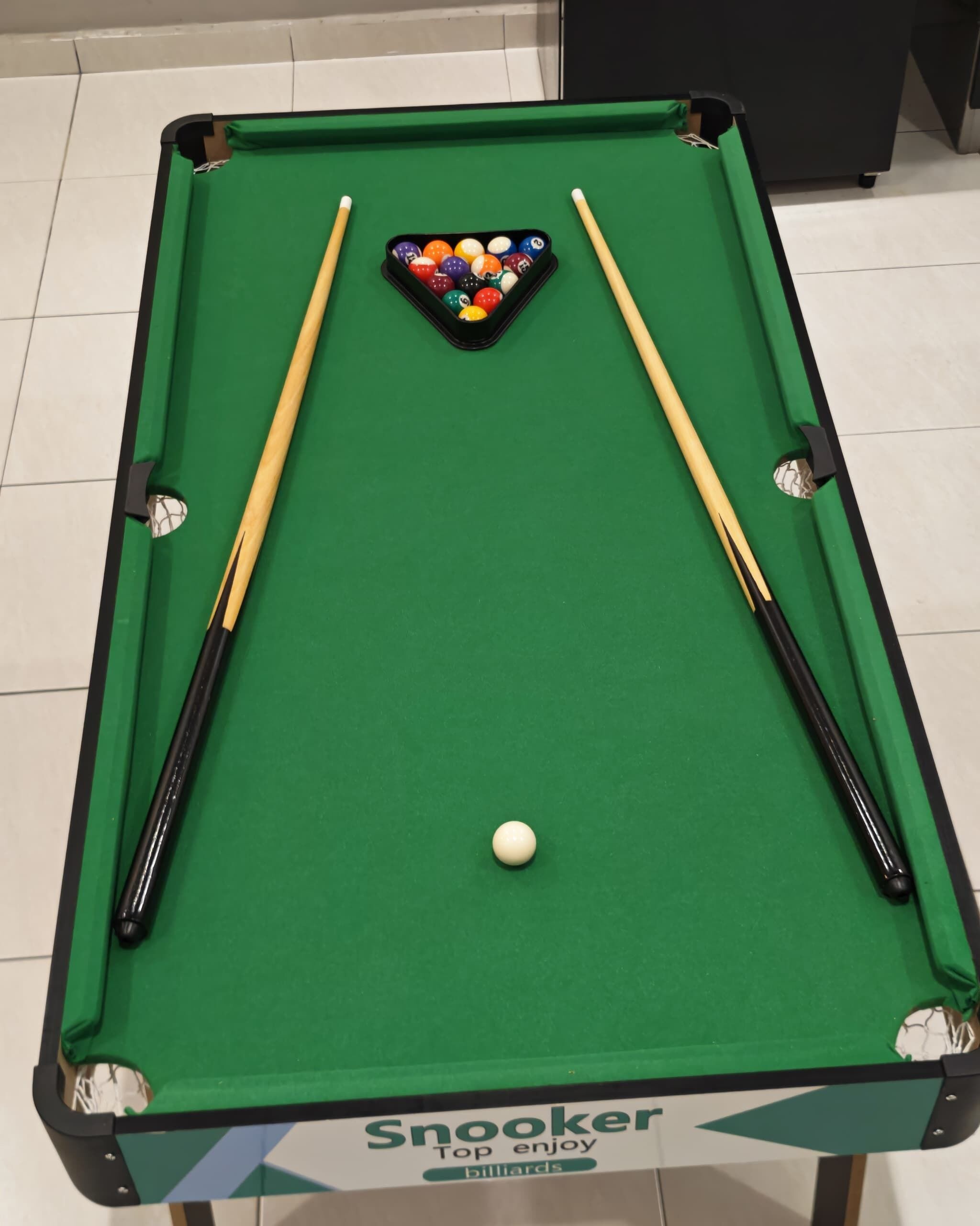 A pool table with a cue ball and a triangle rack of billiard balls, branded 'Snooker Top enjoy billiards.'