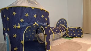 A room with a star-patterned tent-like play area, a bed, and a patterned rug. - Kuantan putra home (Kuala Lipis)