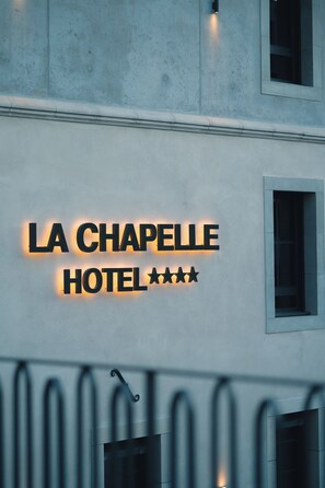 Une enseigne d’hôtel portant le nom « LA CHAPELLE HOTEL » et affichant trois étoiles.