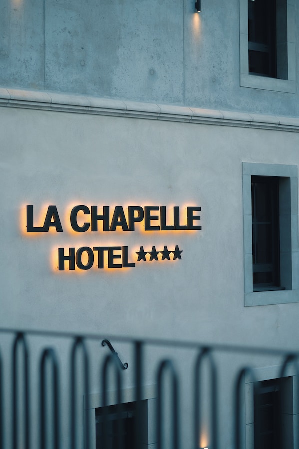 A hotel sign with the name 'LA CHAPELLE HOTEL' and three stars.