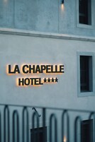 Hotellin kyltti, jossa lukee ”LA CHAPELLE HOTEL” ja jossa on kolme tähteä.