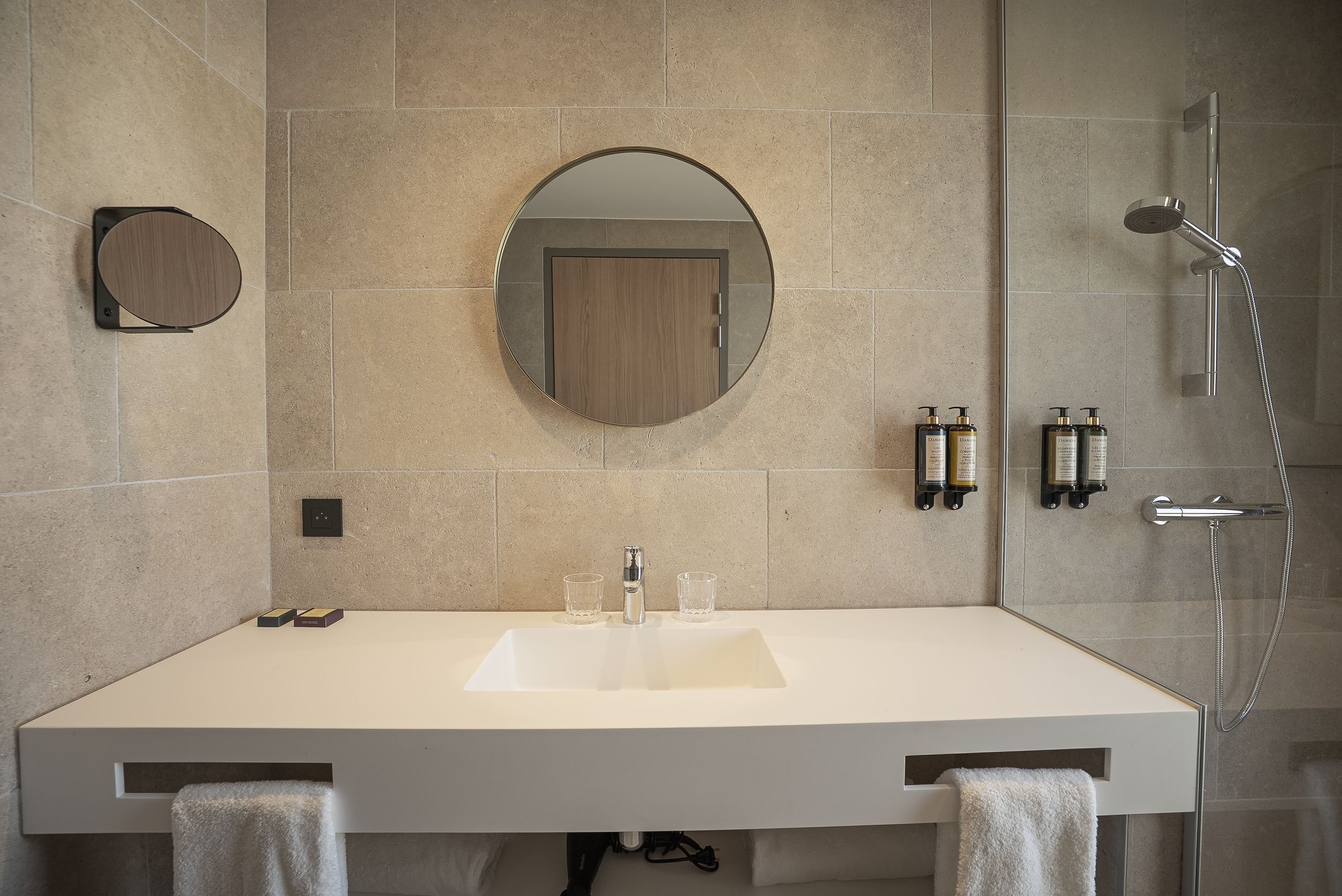 A bathroom with a large sink, mirror, and shower.