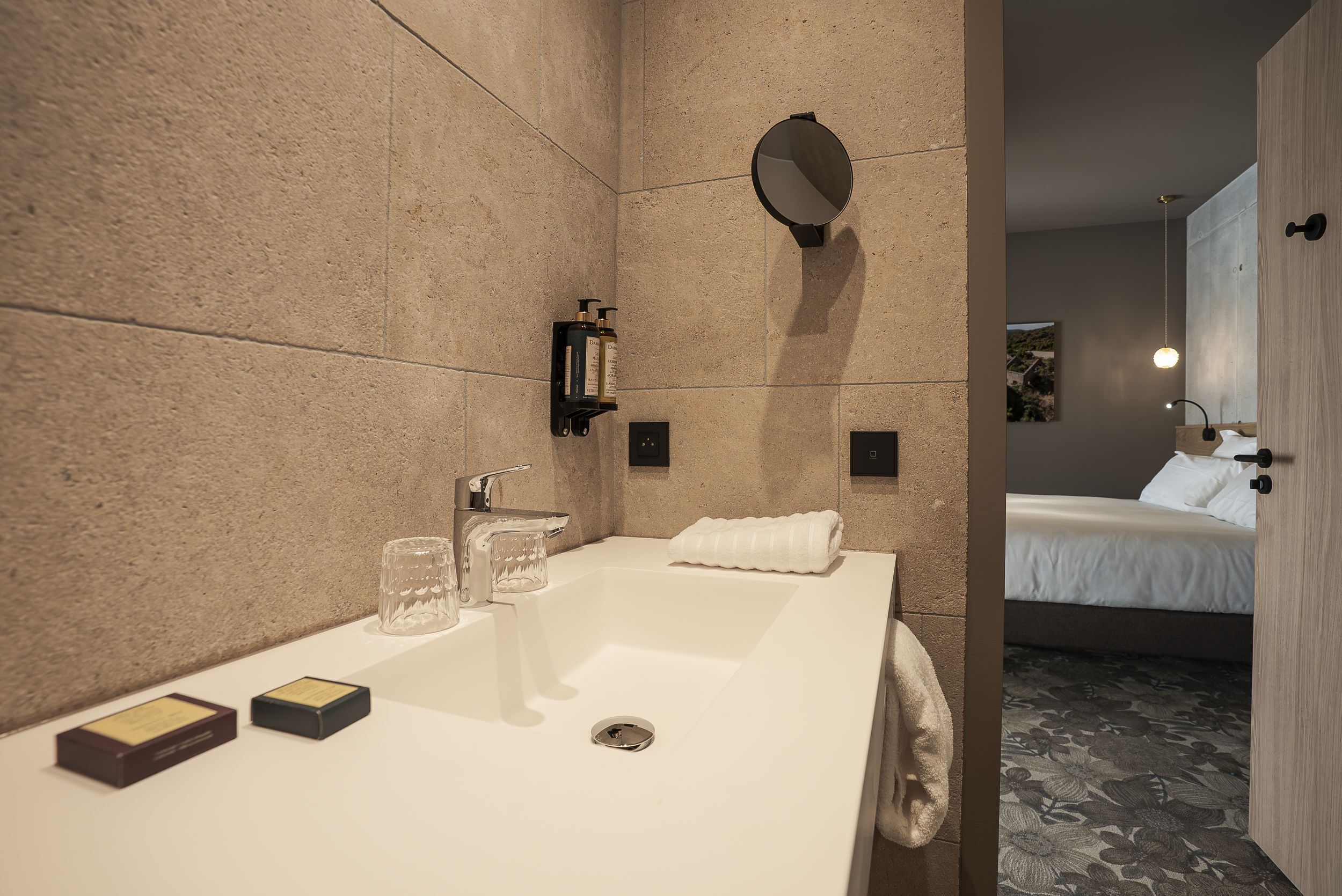 A modern bathroom with a large sink, a mirror, and a towel rack.