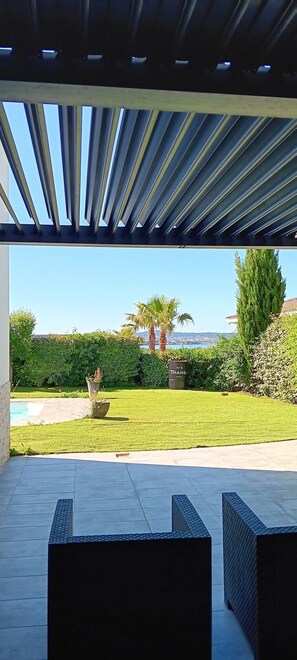 A covered outdoor area with a view of a pool and greenery. - 130m3 loft with view of Thau Lagoon and sea (Poussan)