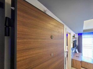 A room with a wooden wardrobe, a small wooden desk, and a window with curtains. - 7 - ILEKTRA Suite by SDR (Paralia)