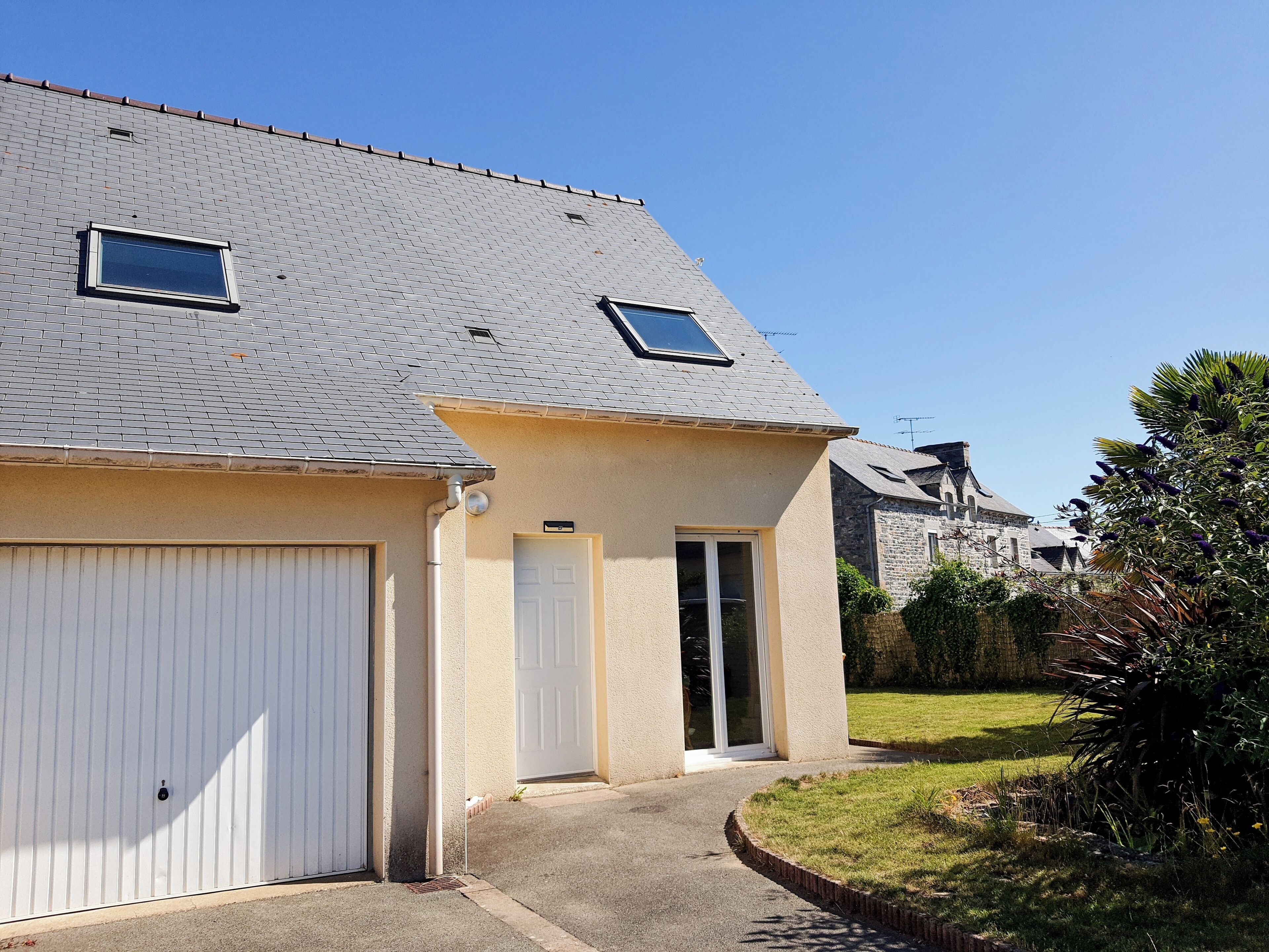 Een woongebouw met garage, een deur en een klein raam.