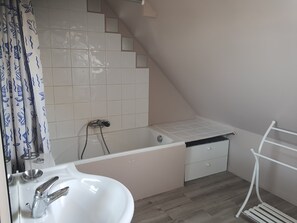 Une salle de bain avec une baignoire, un lavabo et une douche.