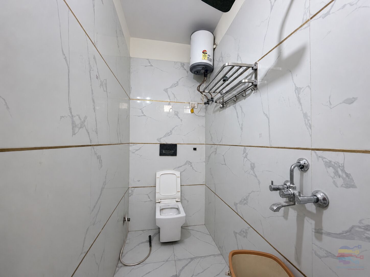Un baño pequeño y moderno con inodoro, ducha y toallero.