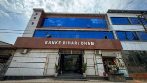 Un edificio de varios pisos con el letrero 'BANKE BIHAR DHAM' en la fachada.