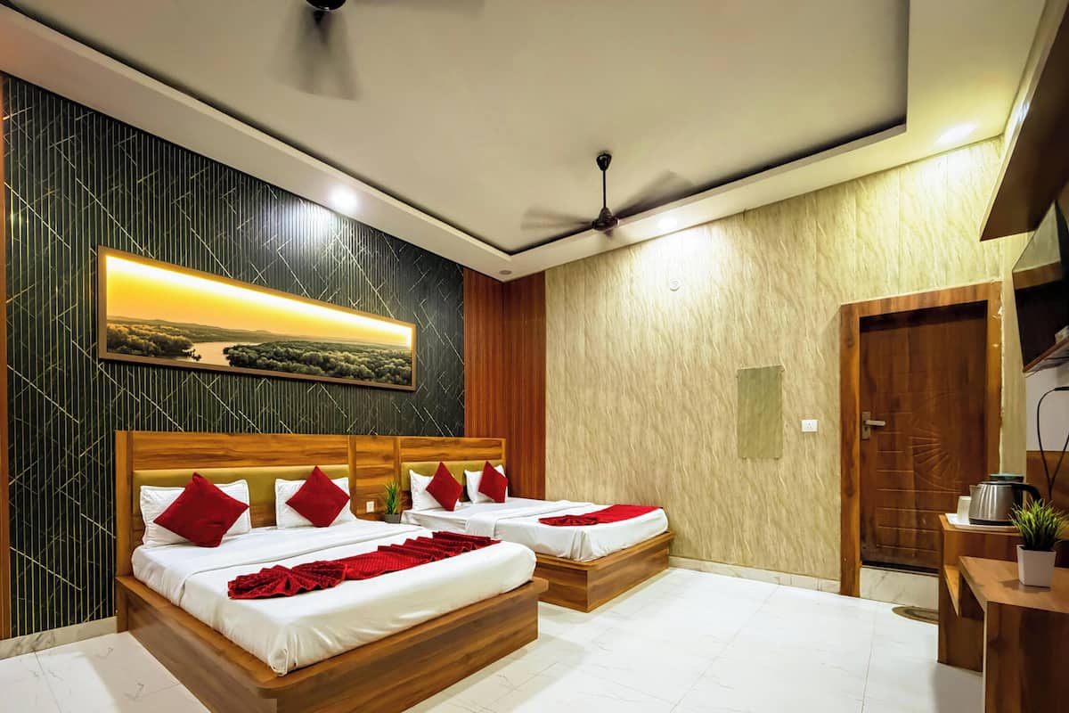 Quarto de hotel com uma cama grande, um ventilador de teto e um quadro na parede.