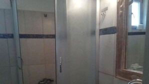 A bathroom with a glass-enclosed shower, a white sink, and a mirror. - Simple Stay Vari s House II (Kropia)