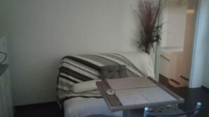 A small, dimly lit room with a bed, a chair, a table, and a mirror. - Simple Stay Vari s House II (Kropia)