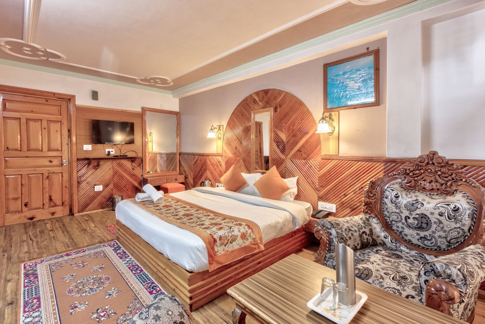 Una habitación de hotel con cama, sofá, televisión y espejo.