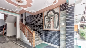 Una escalera con barandillas de madera, un muro de ladrillo negro y un techo decorativo.