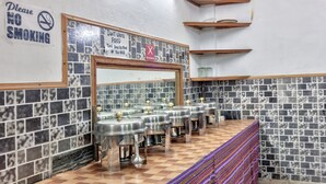 Baño público con paredes de azulejos, piso a cuadros y varios lavamanos.