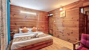 Una habitación con paneles de madera, una cama, una silla y una pequeña mesa.