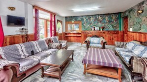 Una sala de estar con un conjunto de sofá, una mesa de centro y una alfombra estampada.