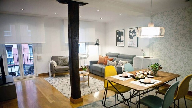 A modern living room with a dining area, a large window, and a staircase. - COSY APARTMENT closed to RIVERSIDE & Parking (Bilbao)