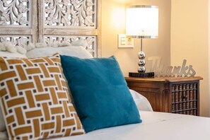 A bed with patterned pillows, a bedside lamp, a decorative wall panel, and a 'Thanks' sign. - Inside old town by Eba Homes (Bilbao)