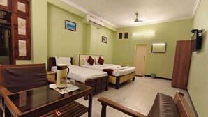 Habitación de hotel con cama, escritorio, silla, sofá, aire acondicionado y televisión.