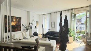 Una sala de estar moderna con un sofá, una mesa de centro, una chimenea y un ventanal grande.