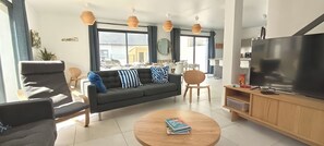 A modern living room with a sofa, armchairs, a coffee table, and a TV. - New house for 13 people. Sandy beach 3 minutes' walk (Bay). Sea views (Saint-Pierre-Quiberon)