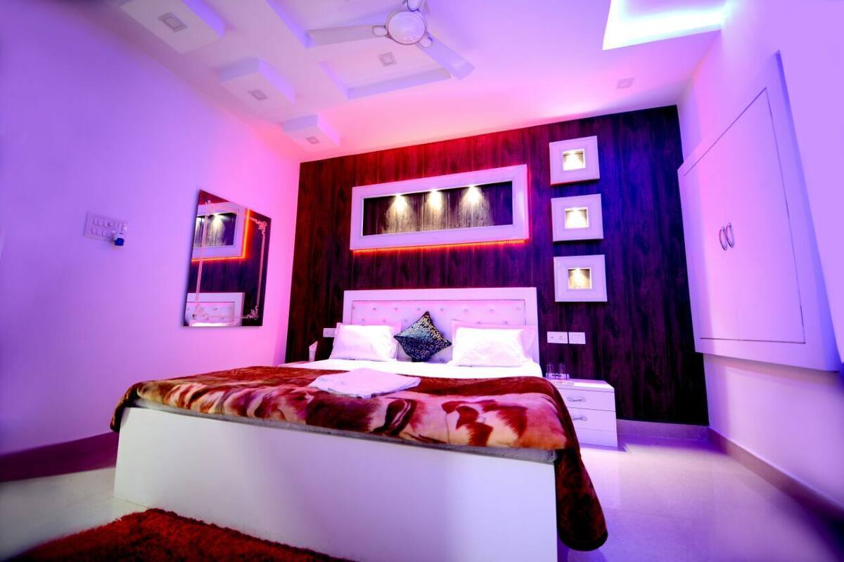 Ein modernes Schlafzimmer mit einem großen Bett, Deckenventilator und eingebauter Beleuchtung.