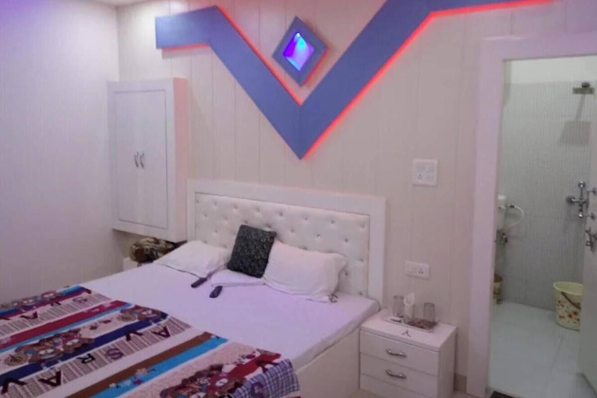 Ein Schlafzimmer mit Bett, Nachttischen, einem Kleiderschrank und einer Duschkabine.
