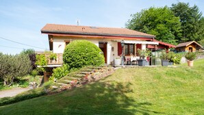 Una casa con techo rojo, un porche delantero y un jardín bien cuidado.