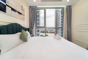Ein Hotelzimmer mit einem großen Bett, Blick auf eine Stadtlandschaft und einem Gemälde an der Wand.