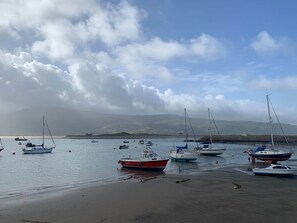 Un port où des bateaux sont amarrés et une plage de sable.