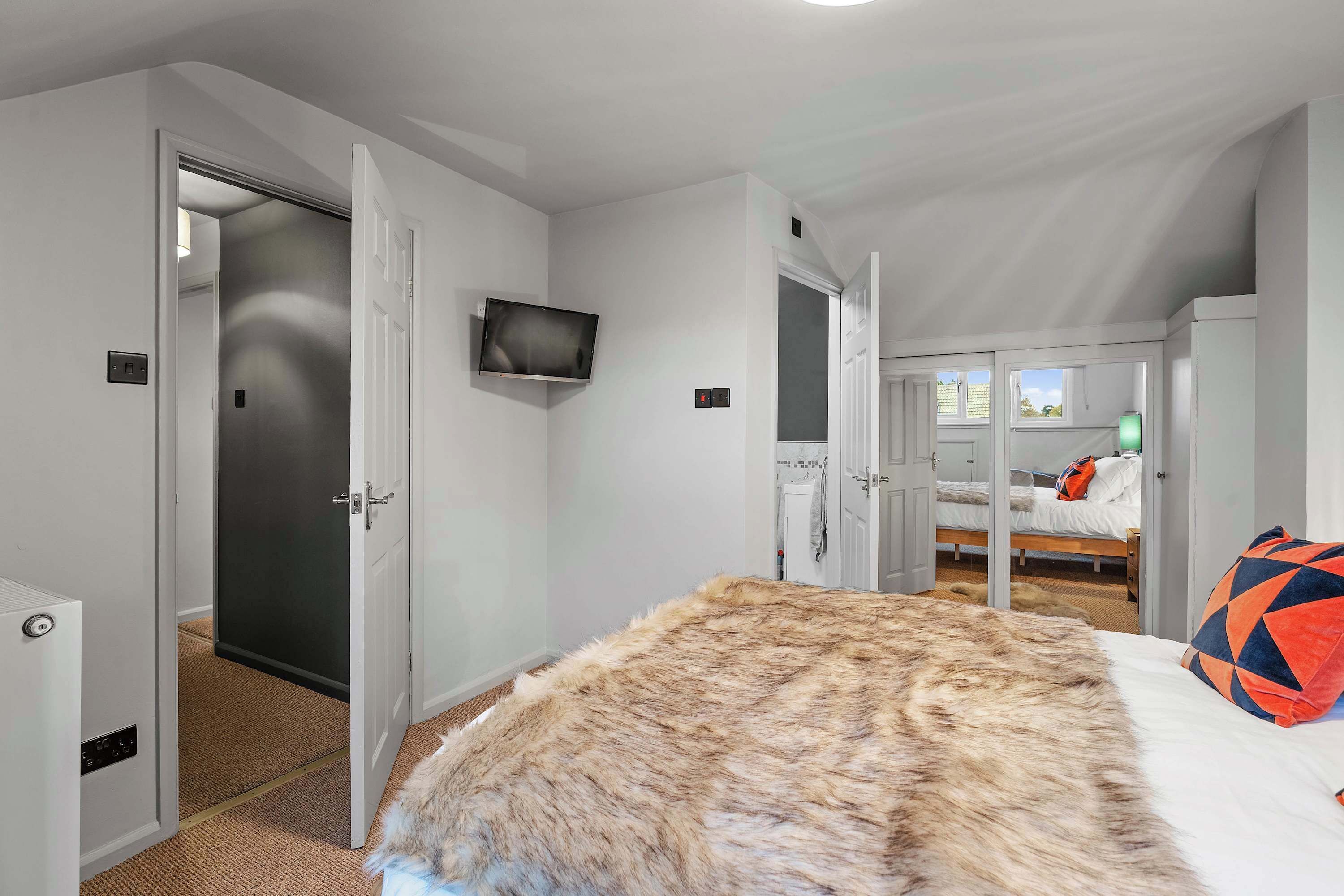 Un dormitorio con una cama, televisor y armario.