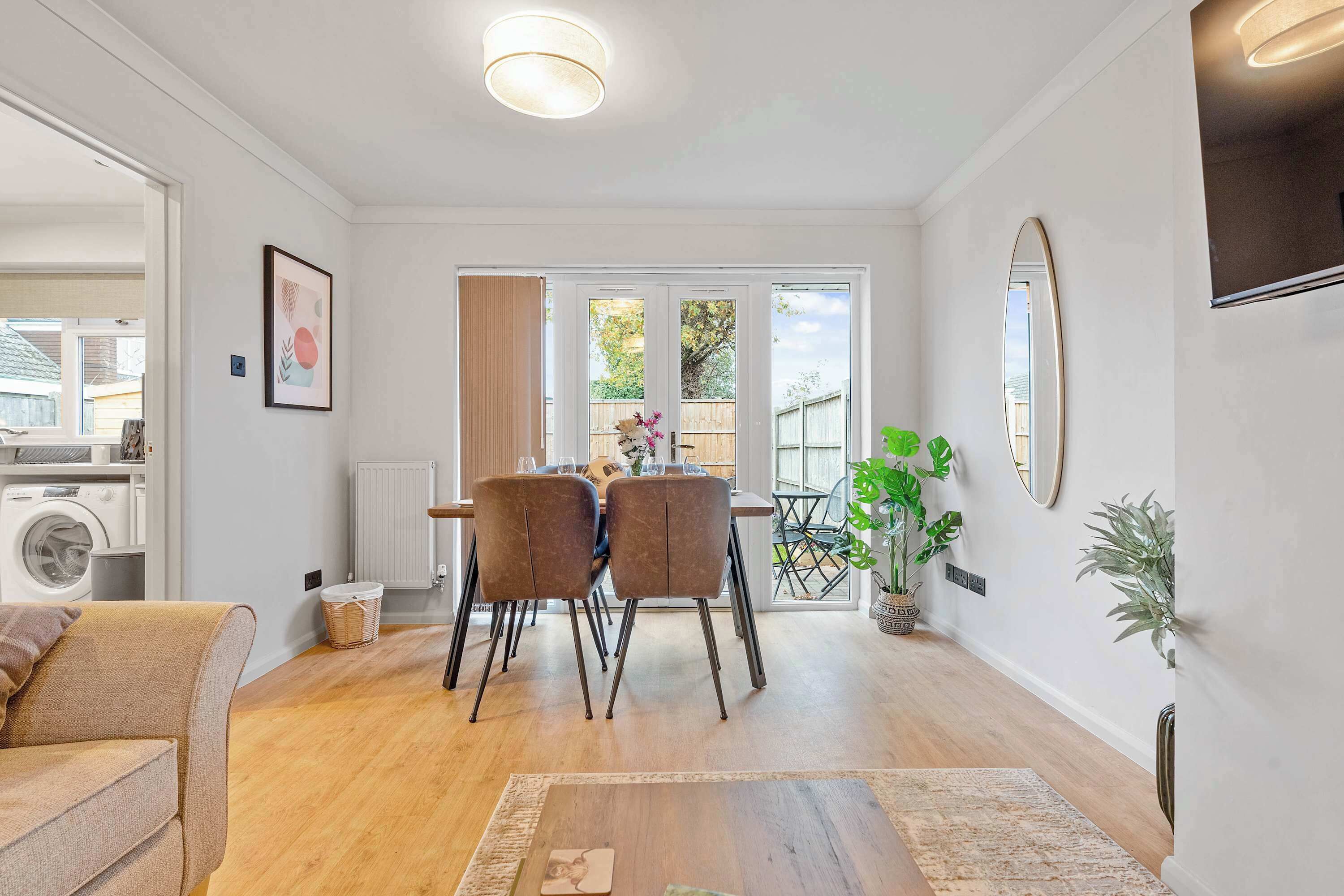 Una sala de estar moderna con comedor, lavadora y un ventanal grande.