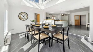 Un comedor con techo alto, tragaluces y vistas a la cocina.