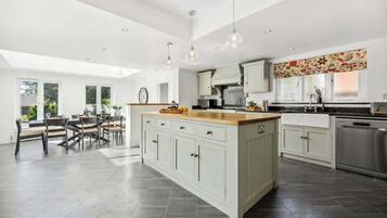 A spacious kitchen with a central island, modern appliances, and pendant lighting.