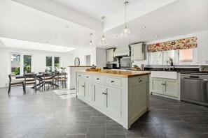 A spacious kitchen with a central island, modern appliances, and pendant lighting. - Windsor Manor: Luxury 5-bed Retreat in Solihull (Solihull)