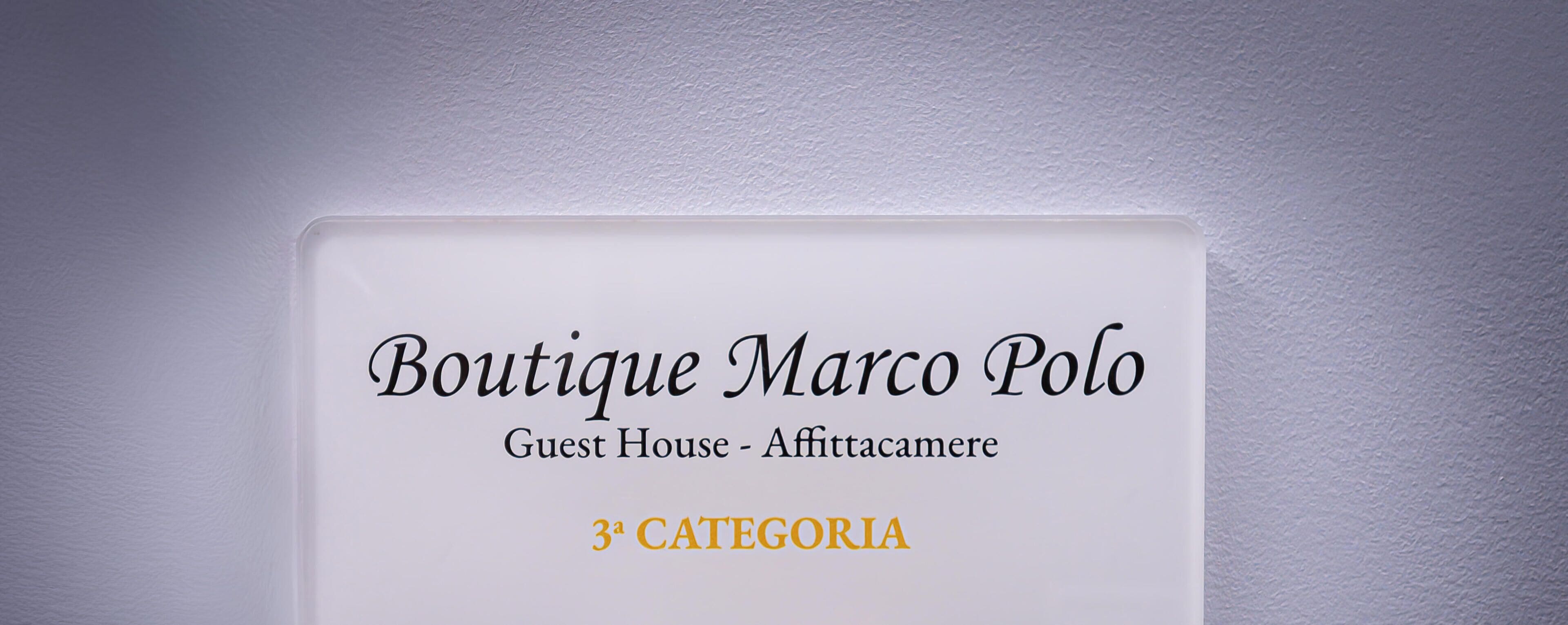 Een bord met de tekst 'Boutique Marco Polo Guest House - Affittacamere 3A CATEGORIA'.